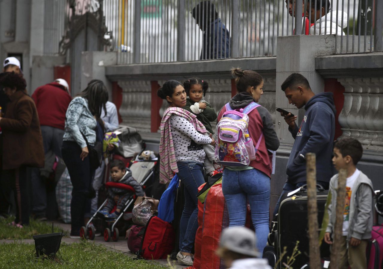 Gevluchte Venezolanen wachten bij de ambassade in Peru op een bus die ze naar de luchthaven brengt.