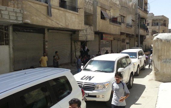 Bewoners verzamelen zich rond de VN-konvooi in Mouadamiya, een buitenwijk van Damascus.