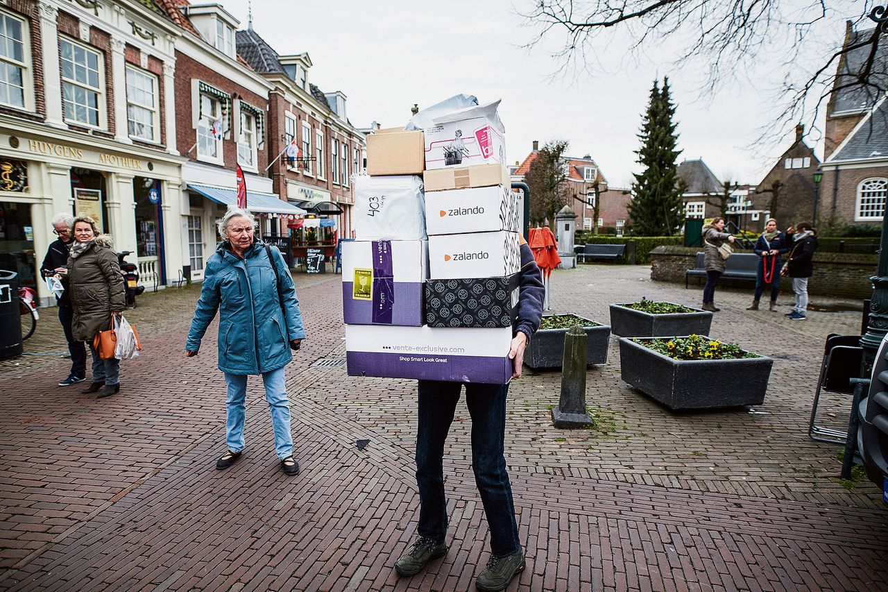 Een bezorger brengt pakketjes naar een ophaalpunt in een supermarkt in Voorburg.