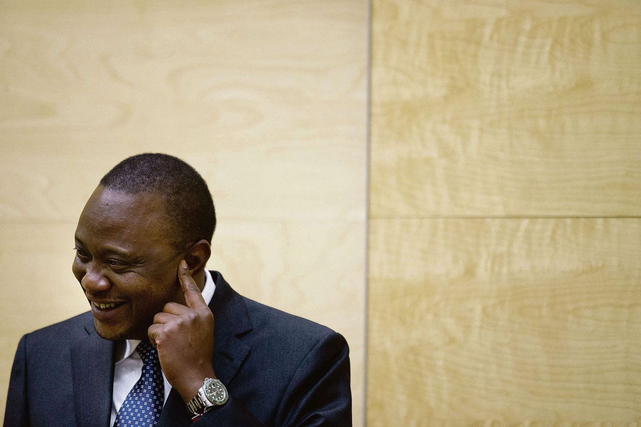 De Keniaanse president Uhuru Kenyatta verschijnt lachend voor het Strafhof in Den Haag.