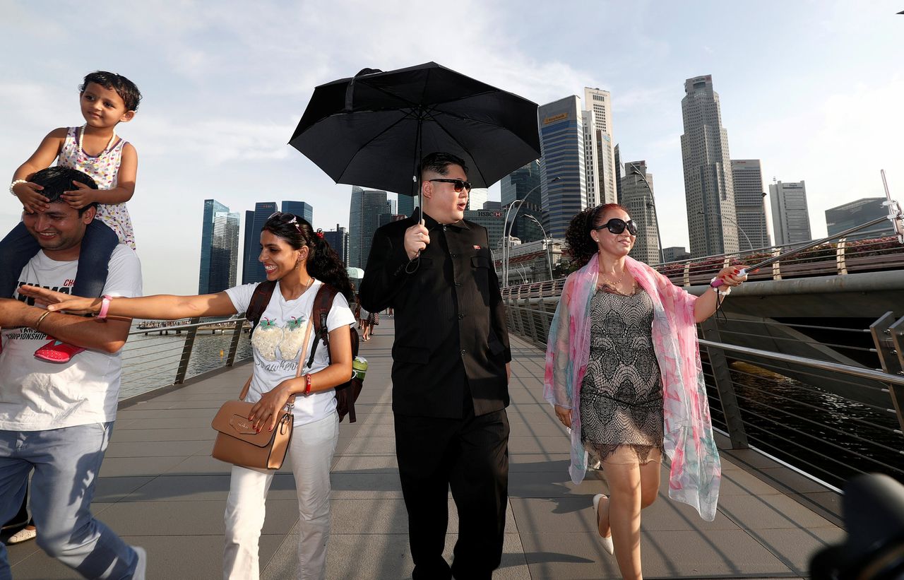 Een Australische Chinees loopt verkleed als de Noord-Koreaanse leider Kim Jong-un over Jubilee Bridge in Singapore.