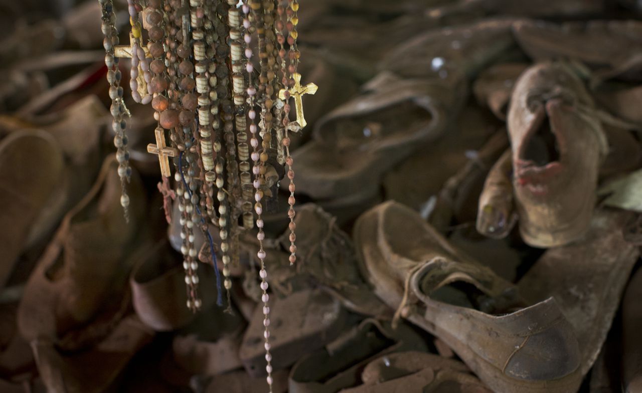 Een herdenkingsmonument in een kerk in Ntarama, Rwanda. De schoenen en de rozenkransen zijn van de slachtoffers, die bescherming zochten in de kerk maar alsnog werden afgeslacht.