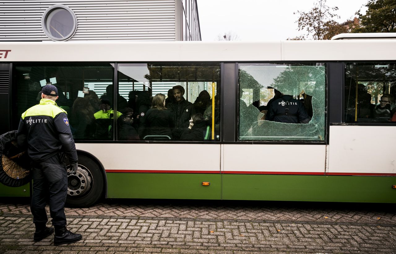 Een bus met tegenstanders van Zwarte Piet komt aan bij het politiebureau in Maassluis.