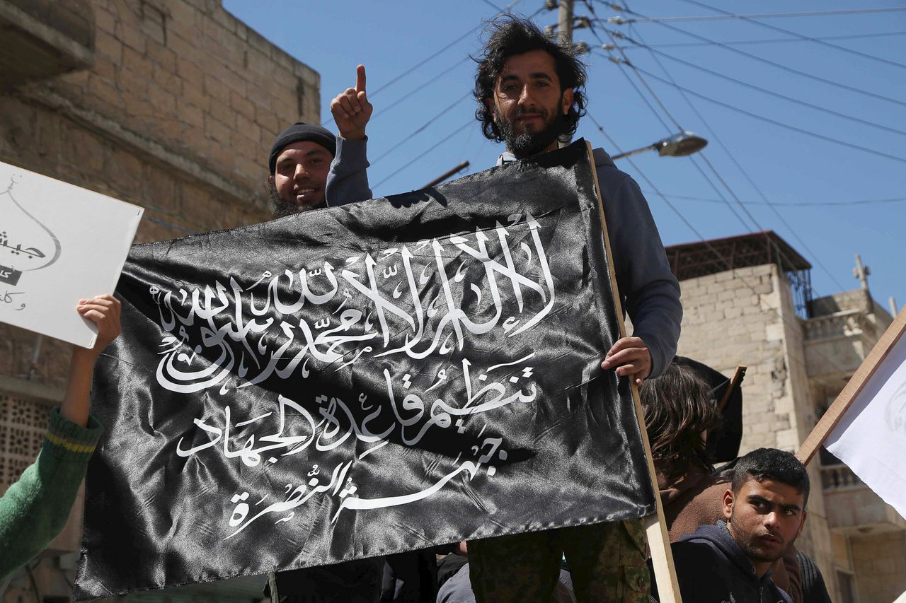 Inwoners van Idlib met de vlag van Al-Nusra nadat de rebellen de stad vorige maand op het regeringsleger hadden veroverd.