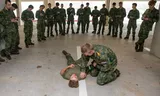 Mbo-studenten van de Zadkine Veiligheidsacademie in Rotterdam wonen  een demonstratie eerste hulp bij tijdens een militaire training. 