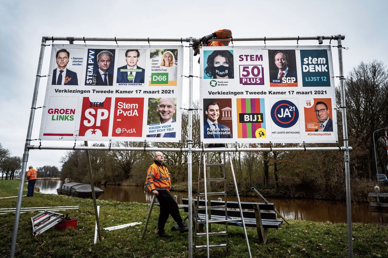 Medewerkers van een aannemersbedrijf plaatsen verkiezingsborden in de gemeente Midden-Groningen.