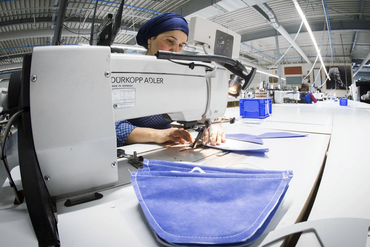 Medewerkers bereiden mondkapjes voor in een naaiatelier van beddenfabrikant Auping.